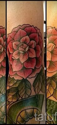 A kamélia tetoválás hűvös változata a fotón egy megjegyzés a kamélia virágmintájának értelmezéséről egy tetoválásban