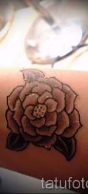 A kamélia tetoválás szokatlan változata a fotón a kamélia virág tetoválásba történő rajzolásának anyagához