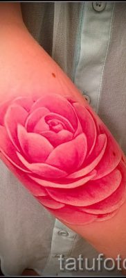 A kamélia tetoválás érdekes változata a fotón egy cikkhez, amely a kamélia virág tetoválásba történő rajzolásának történetéről szól