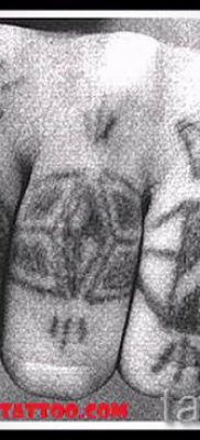 Egy fotó egy menő tetoválásról, amelyet már a testre alkalmaztak egy ujjal, egy kereszttel a saját rajz kiválasztásához és létrehozásához - egy lehetőség