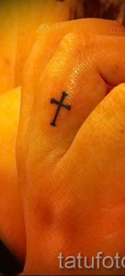 Egy fotó egy hűvös meglévő tetoválásról egy ujjal, egy kereszttel a saját rajz kiválasztásához és rajzolásához - ötlet