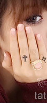 Fénykép egy figyelemre méltó kész tetoválásról egy ujjal, egy kereszttel a saját rajz kiválasztásához és rajzolásához - egy lehetőség