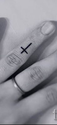 Fénykép egy figyelemre méltó meglévő tetoválásról egy ujjal, kereszttel, hogy kiválassza és elkészítse saját vázlatát - ötlet