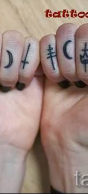 Egy fénykép egy érdekes meglévő tetoválásról egy ujjal, egy kereszttel a saját rajz kiválasztásához és rajzolásához - példa