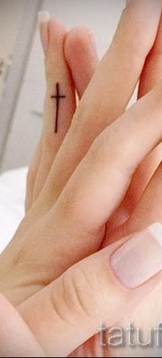 Fotó egy hűvös meglévő tetoválásról egy ujjal, egy kereszttel, hogy kiválassza és lerajzolja saját tervezését - ötlet