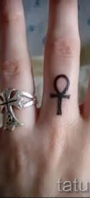 Fénykép egy méltó meglévő tetoválásról egy ujjal, kereszttel a saját vázlat kiválasztásához és létrehozásához - ötlet