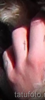 Fotó egy hűvös meglévő tetoválásról egy ujjal, egy kereszttel, hogy kiválassza és létrehozhassa saját dizájnját - példa