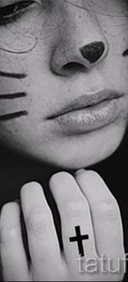 Egy fotó egy szokatlan kész tetoválásról egy ujjal, egy kereszttel a saját vázlat kiválasztásához és rajzolásához - ötlet