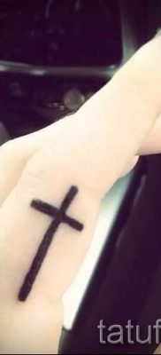 Fotó egy hűvös meglévő tetoválásról egy ujjal, egy kereszttel, hogy kiválassza és lerajzolja saját vázlatát - egy lehetőség