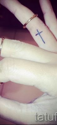 Fénykép egy méltó meglévő tetoválásról egy ujjal, kereszttel a saját rajz kiválasztásához és létrehozásához - egy lehetőség