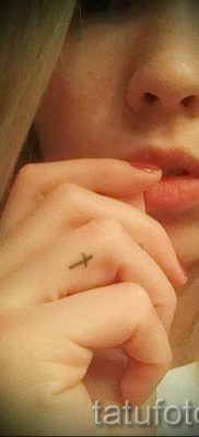 Fénykép egy figyelemre méltó tetoválásról az ujján, amelynek keresztje már fel van helyezve a testre a saját rajz kiválasztásához és létrehozásához - opció