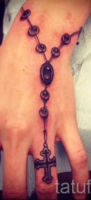 Fénykép egy figyelemre méltó tetoválásról az ujján, amelynek keresztje már fel van helyezve a testre a saját vázlat kiválasztásához és létrehozásához - opció