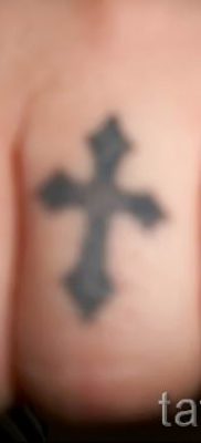 Fénykép egy érdekes tetoválásról az ujján, amelynek keresztje már fel van helyezve a testre a saját vázlat kiválasztásához és rajzolásához - opció