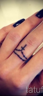 Fotó egy hűvös meglévő tetoválásról egy ujjal, egy kereszttel a saját rajz kiválasztásához és rajzolásához - példa