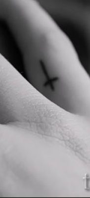 Egy fotó egy szokatlan tetoválásról az ujján, amelynek keresztje már fel van helyezve a testre a saját rajz kiválasztásához és rajzolásához - ötlet