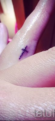 Fotó egy hűvös meglévő tetoválásról egy ujjal, egy kereszttel a saját vázlatának kiválasztásához és rajzolásához - példa