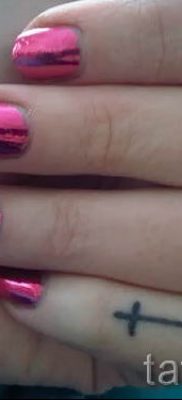 Egy fotó egy szokatlan tetoválásról az ujján, amelynek keresztje már fel van helyezve a testre a saját rajz kiválasztásához és létrehozásához - egy lehetőség