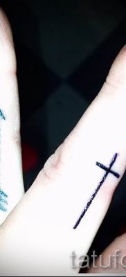 Egy fotó egy érdekes kész tetoválásról egy ujjal, egy kereszttel a saját vázlatának kiválasztásához és rajzolásához - ötlet