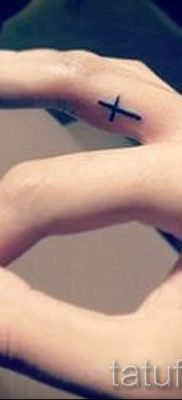 Fotó egy hűvös meglévő tetoválásról egy ujjal, egy kereszttel a saját rajz kiválasztásához és létrehozásához - példa