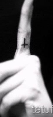 Fotó egy szokatlan kész tetoválásról egy ujjal, egy kereszttel a saját vázlatának kiválasztásához és rajzolásához - egy lehetőség