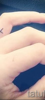 Fénykép egy figyelemre méltó tetoválásról az ujján, amelynek keresztje már fel van helyezve a testre a saját vázlat kiválasztásához és létrehozásához - opció