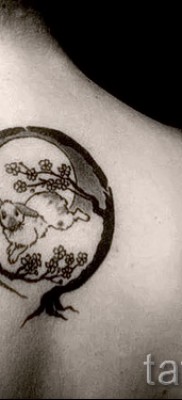 Снимка на заешка татуировка между лопатките под врата