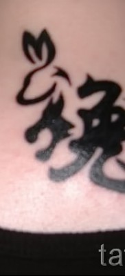 Снимка на татуировка на заек и йероглиф на врата