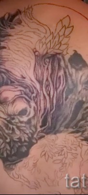 Fotó példa egy orrszarvú tetoválásra és egy koponyára a hátán