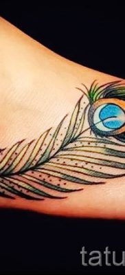 Egy fotó egy szokatlan pávatoll tetoválásról, amelynek rajza borjúhoz vagy lapockához alkalmas - a tetováló anyag jelentése