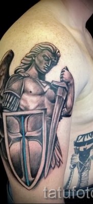 Fénykép egy pajzs tetoválásáról egy harcos kezében