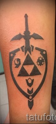 A pajzs és a kard sikeres tetoválásának ötlete a karddal ellátott pajzs tetoválásának jelentéséről