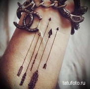 vékony nyilak a kar tetoválásában