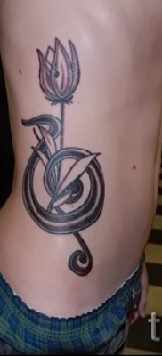 tulipán tetoválás fotó - változat egy magaskulcsos kulccsal egy srác oldalán
