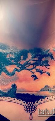 tetoválás a lány mellkasán - szél és fa - szín - fotó