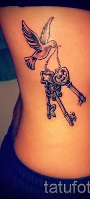 Пример за снимка на татуировка с ключалка - с птица - изпълнена отстрани на момиче