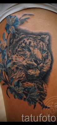 Fotó a leopárd tetoválásról - rajz virággal a lány lábán