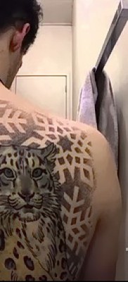 Fotó egy leopárd tetoválásról - hópelyhekkel dolgozva egy srác jobb lapockáján