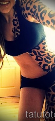 Fotó egy leopárd tetoválásról - színezés foltokkal a lány testének padlóján