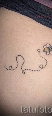 Fotó egy méh tetoválásról - tetoválás egy lány bugyija és egy szaggatott vonal közelében