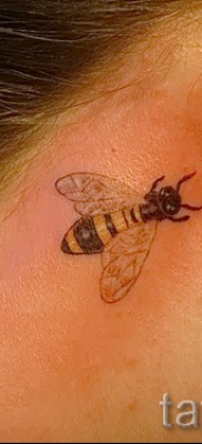 Fotó egy méh tetoválásról - kis tetoválás a lány füle mögött