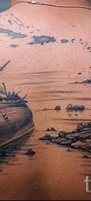 Fénykép tetováló vitorlásról, amely törött a köveken a hátán