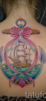 Fotó egy vitorlás tetoválásról egy lány háta közepén - színes munka