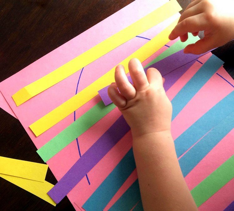 drotár s batoľatami na Veľkú noc s prúžkami papierového veľkonočného vajíčka