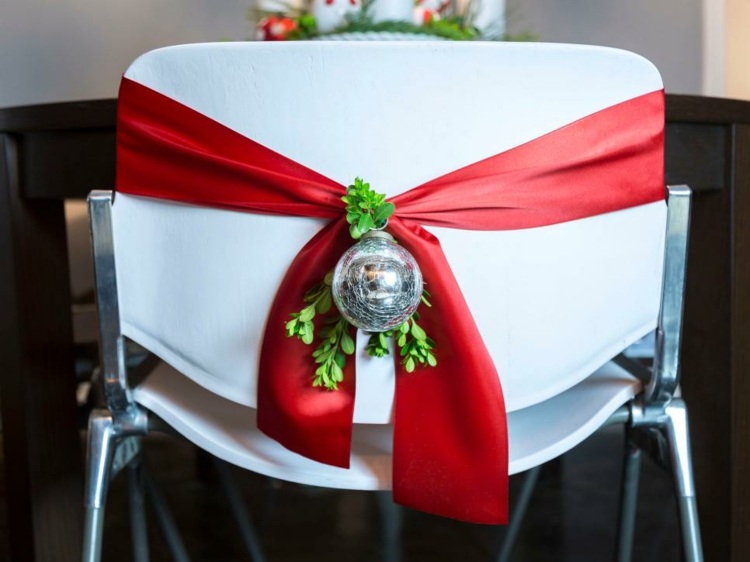 Vianočný malý byt zariadený stoličkami zdobí jednoducho stužkové pleso imelo